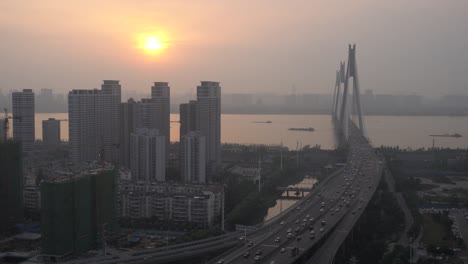 Wuhan,-China,-haze-el-tiempo,-puesta-de-sol-en-las-ciudades-ribereñas,-altos-edificios,-puente,-barcos-en-el-río