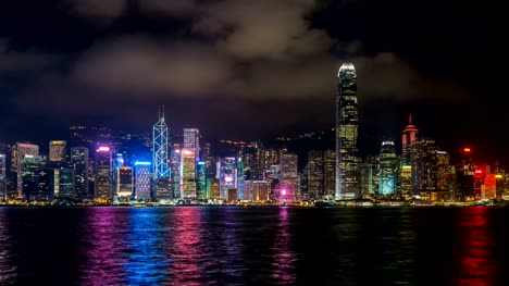 Lapso-de-tiempo-de-los-rascacielos-y-barco-flotante-en-el-puerto-de-Victoria,-Hong-Kong-de-noche.-4K