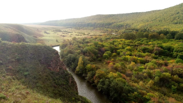 Vista-aérea-del-material-de-archivo-de-Drone:-Vuelo-otoño-montañas-y-pequeños-ríos-con-bosques-en-luz-suave-del-amanecer.-Majestuoso-paisaje.