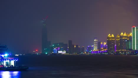 night-illuminated-wuhan-city-riverside-bay-megatall-building-panorama-4k-time-lapse-china