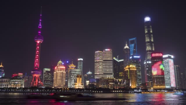 Lapso-de-tiempo-de-noche-panorámica-del-Skyline-de-Shanghai-iluminado.-Distrito-financiero-de-Lujiazui-y-río-Huangpu.-Vista-desde-el-terraplén-del-Bund.-China.