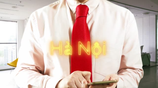 HA-NOI-Guangzhou.-Geschäftsmann-Betrieb-ein-intelligentes-Gerät-wählt-а-Stadt-auf-hellem-Hintergrund