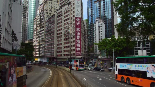 Iconic-double-decker-city-tram-and-bus-passing-on-the-street-of-downtown-city-Hong-Kong,-China-in-Asia