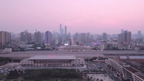 Estación-de-ferrocarril-con-un-campanario-y-una-torre-de-la-ciudad-al-atardecer