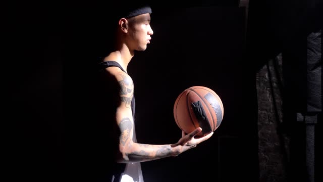 Gut-aussehend-Basketballspieler-mit-Tattoos-mit-Ball-spielen-und-warten-auf-Spiel-starten