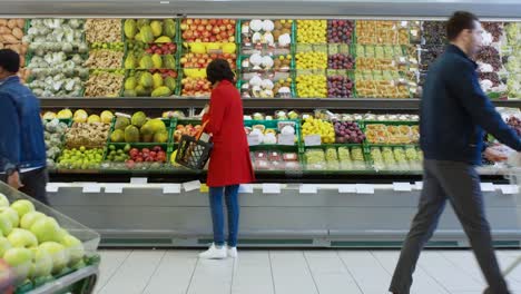 At-the-Supermarket:-Woman-Chooses-Organic-Fruits-in-the-Fresh-Produce-Section-of-the-Store.-She-Picks-Up-Cantaloupe-and-Puts-them-into-Her-Shopping-Basket.-Back-View-Shot.