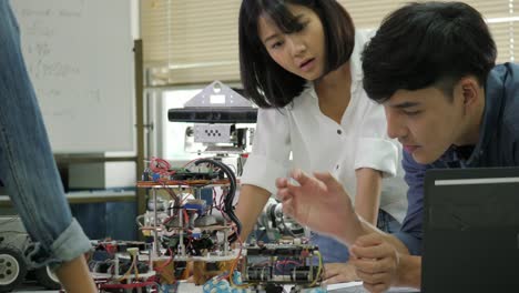 Equipo-de-ingeniero-electrónico-trabajando-juntos,-colaborando-en-un-proyecto-para-construir-el-robot.-Personas-con-el-concepto-de-tecnología-o-innovación.