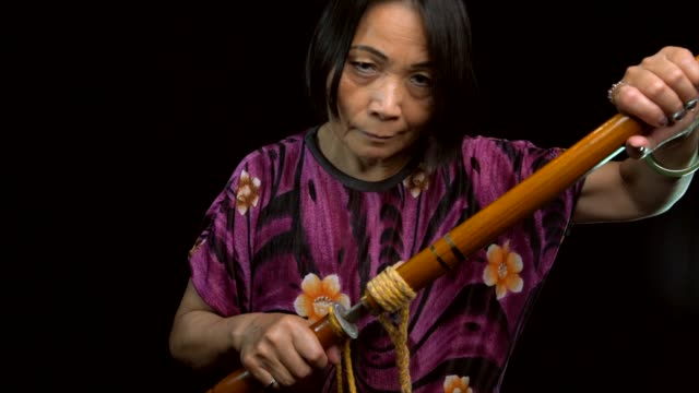 mujer-asiática-tirando-vintage-espada-de-vaina