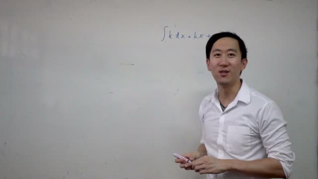 Young-handsome-Asian-math-teacher-writing-a-math-formula-equation-on-white-board-during-lesson.-Education-and-school-concept
