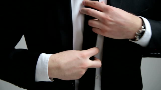 Hombre-de-negocios-abotonarse-un-botón-en-su-chaqueta-negra