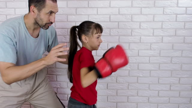 Boxer-training.-A-man-is-training-a-child-in-boxing-gloves.