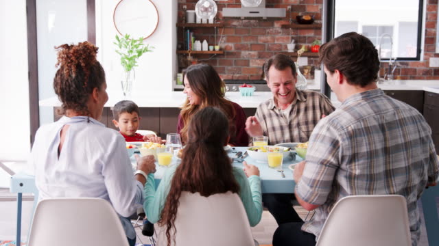Multi-Generationen-Familie-beten-vor-dem-Essen-Tisch-zu-Hause