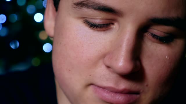 close-up-portrait-of-sad-depressed-young-man-starting-crying,-Christmas--half-face
