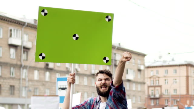 European-people-at-rally.-Caucasian-man-with-a-banner-screaming-into-mouthpiece.