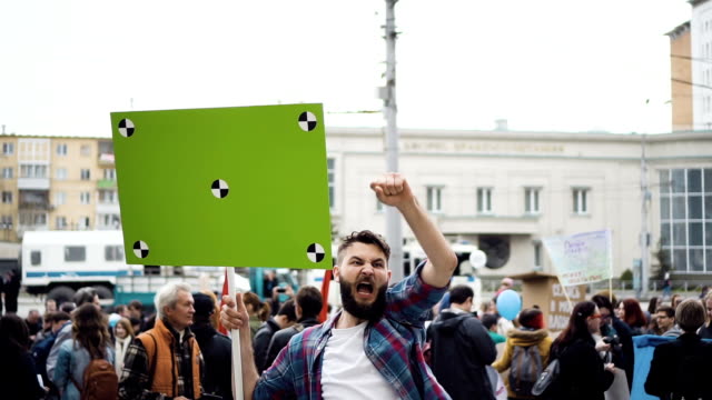 European-people-at-demonstration.-Man-with-a-banner-screaming-into-a-mouthpiece.