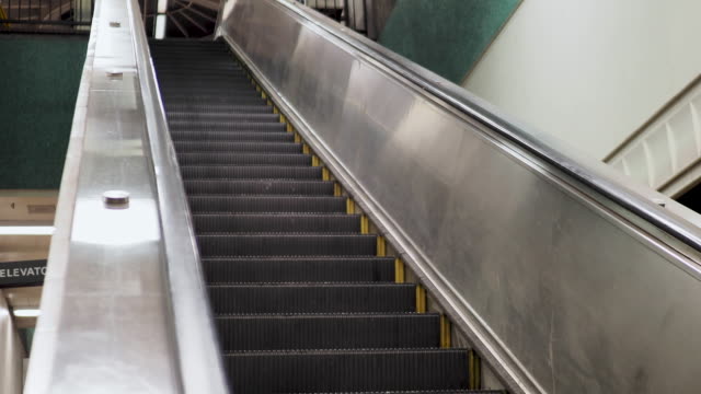 Ángulo-de-tiro-de-escalera-bajando-en-la-estación-de-metro