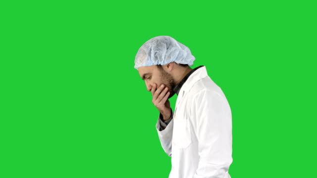 Doctor-man-walking-stressed-with-hand-on-head,-shocked-with-shame-and-surprise-face,-angry-and-frustrated-Fear-and-upset-for-mistake-on-a-Green-Screen,-Chroma-Key