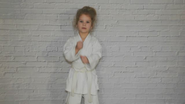 niña,-niño-en-un-kimono-en-el-entrenamiento-de-karate-trabaja-a-golpes-y-un-saludo