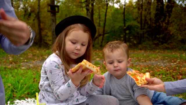 kleine-Mädchen-kaut-und-behandelt-ein-Stück-Pizza.