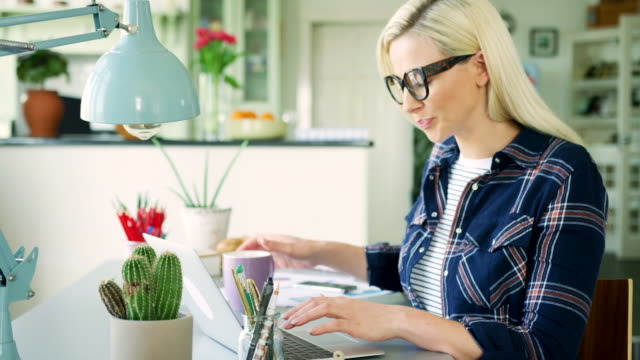Attractive-Blond-Businesswoman-Typing-On-Laptop-At-Home-Office