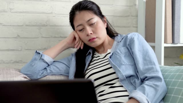 gelangweilte-Hausfrau-mit-Laptop-beim-Einschlafen