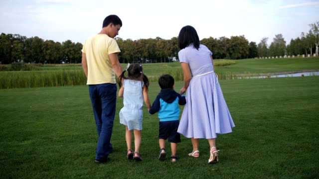 Asian-family-holding-hands-and-walking-outdoors