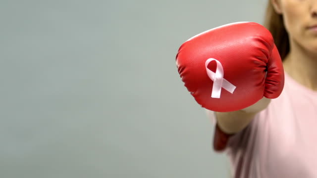 Pink-ribbon-pinned-on-boxing-glove,-concept-of-woman-fighting-breast-cancer
