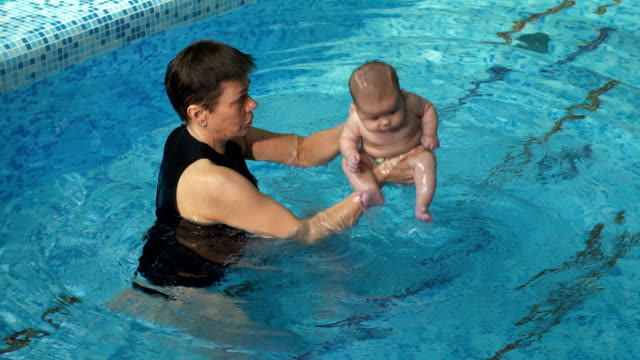 Entrenador-con-bebé-en-la-piscina