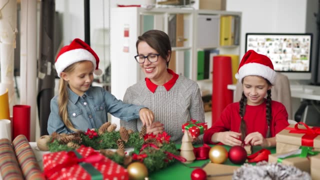Fröhliche-Frau-und-kleine-Mädchen-machen-Weihnachtsvorstellungen-zusammen
