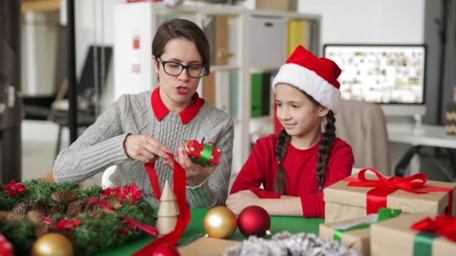 Frau-lehrt-Mädchen,-wie-man-Weihnachten-Geschenkbox-macht