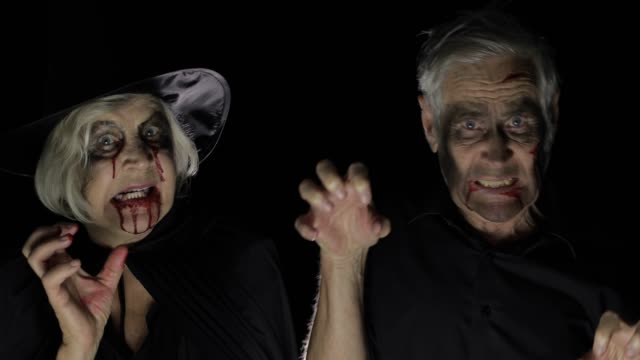 Elderly-man-and-woman-in-Halloween-costumes.-Witch-and-zombie