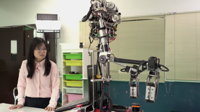Asiatische-Ingenieurstudenten-beherrschen-Joystick-und-testen-Robotik-im-modernen-Labor.-Konzept-von-Robotern,-Technologieentwicklungen-und-Kollaboration.