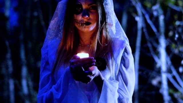 Halloween.-The-woman-with-spooky-make-up-holding-in-the-arms-a-wax-candle.-4K