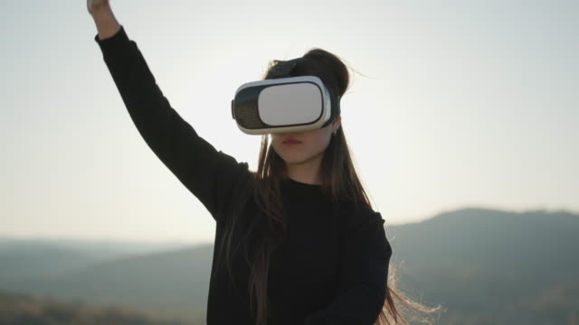 Frau-verwendet-Virtual-Reality-Brille-bei-Sonnenuntergang.-Abendzeit,-Dämmerung.-Relax,-Entertainment-und-Technologiekonzept