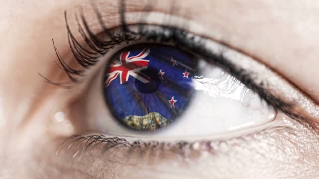 Frau-grünes-Auge-in-Nahaufnahme-mit-der-Flagge-von-Neuseeland-in-Iris-mit-Windbewegung.-Videokonzept