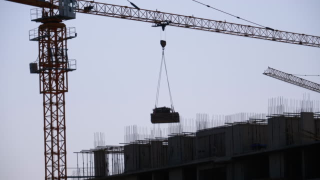 Tower-Crane-on-a-Construction-Site-Lifts-a-Load-at-High-rise-Building