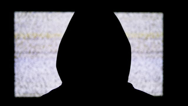 Silhouette-des-Kopfes-des-Menschen-in-Kapuze-beobachtet-weiße-statische-Geräusche-und-TV-Interferenzen