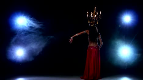 Attractive-belly-dancer-girl-go-on-dancing-with-candles,-her-head,-black,-smoke