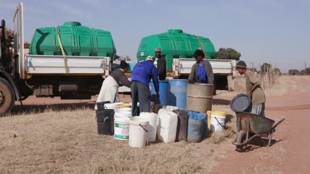 Menschen-in-Afrika-sammeln-Wasser-in-Behältern-aus-Tankfahrzeugen-Wasser-aufgrund-der-schweren-Dürre-in-Südafrika