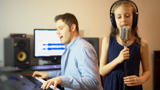 Man-with-little-girl-rehearsing-song-in-music-studio.