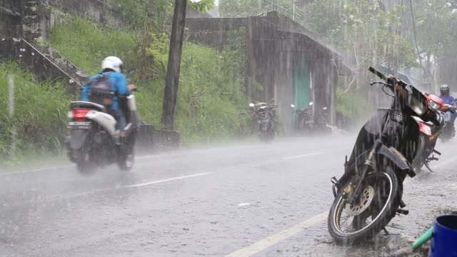 Verkehr-auf-eine-typische-Straße-auf-der-Straße-während-des-Regens-in-Insel-Bali,-Indonesien