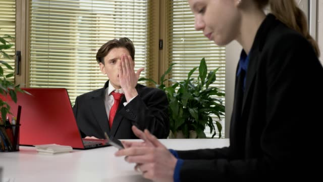 young-guy-in-a-suit-sends-an-air-kiss-to-a-female-employee.-A-sign-of-a-kiss,-flirts,-work-in-the-office-concept.-60-fps
