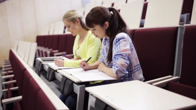 student-girls-with-notebooks-in-lecture-hall