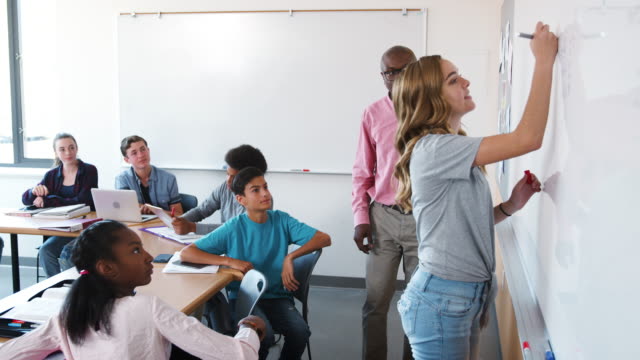 High-School-Schüler-schreiben-auf-Whiteboards-In-Mathematik-Klasse