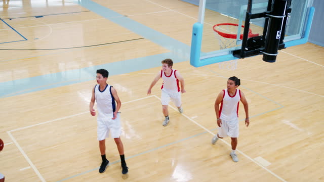 Selección-de-baloncesto-de-secundaria-hombre-anota-canasta-en-corte-y-celebrar