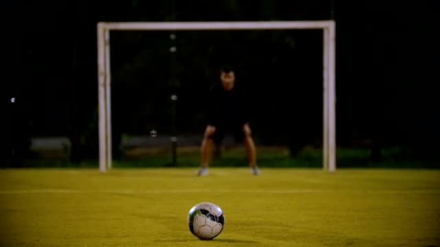 The-ball-lies-on-the-grass-in-the-foreground,-the-goalkeeper-is-at-the-gate,-the-other-player-kicks-the-ball,-but-does-not-hit-the-goal