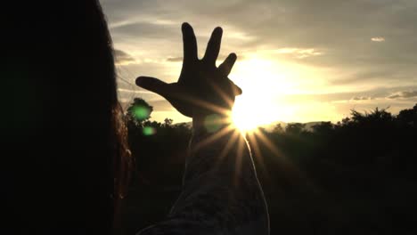 Sunlight-through-female-hands-while-her-looking-at-sun