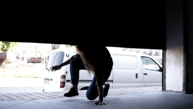 Female-and-male-zombies-are-chasing-the-girl-on-the-street.-Young-girl-running-in-scary-and-hiding-in-garage-around-the-corner.-Slow-motion