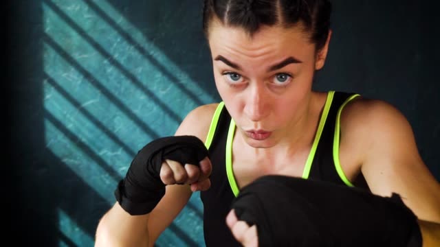 Closeup-Retrato-mujer-hermosa-joven-boxeo-entrenamiento-perforando-en-gimnasio-en-cámara-lenta