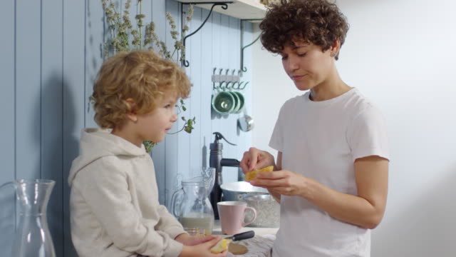 Mutter-Making-Sandwiches-für-Cute-Boy-in-Küche